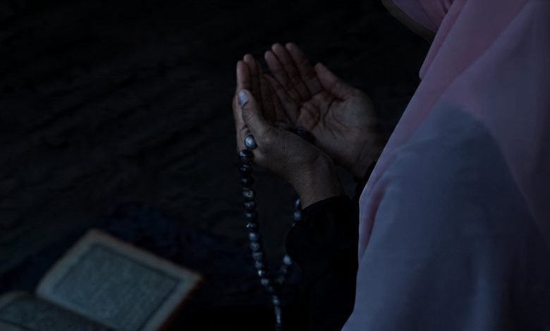 Muslim Women is praying in mosque raising hands for dua